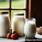 Home 22 수제 요구르트에 필요한 재료와 방법 - A cozy kitchen scene featuring a rustic wooden table with various types of milk bottles—whole milk, ...
